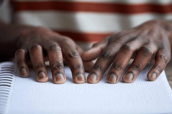 Hands reading Braille text