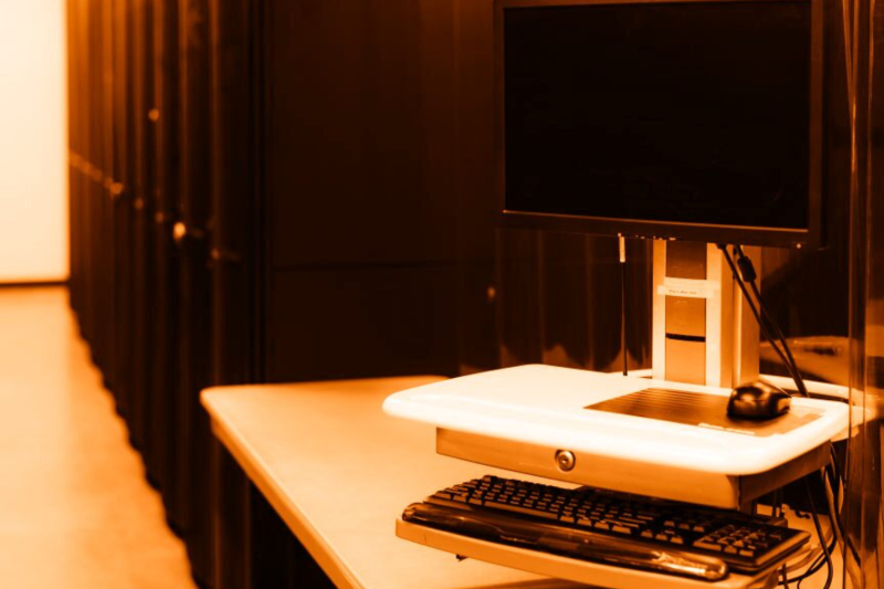 An Image of data cabinets and a computer screen on a table